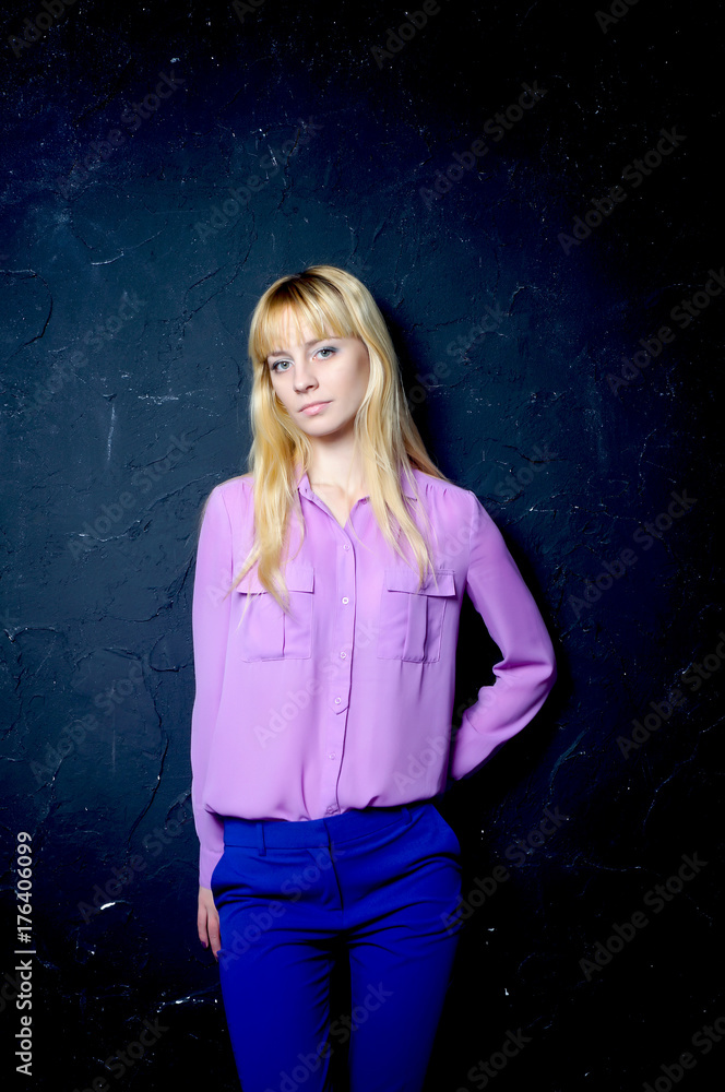 Beautiful young girl posing by the dark wall Beautiful young girl posing by the dark wall