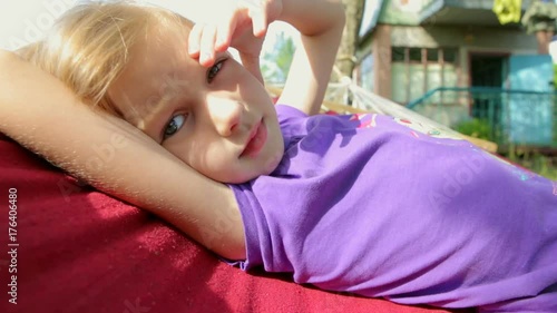 the child is resting on the hammock