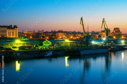 urban night view with cranes at river