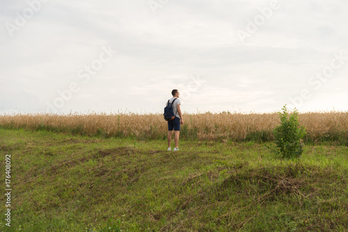A man standing on the grass looking towards the sun