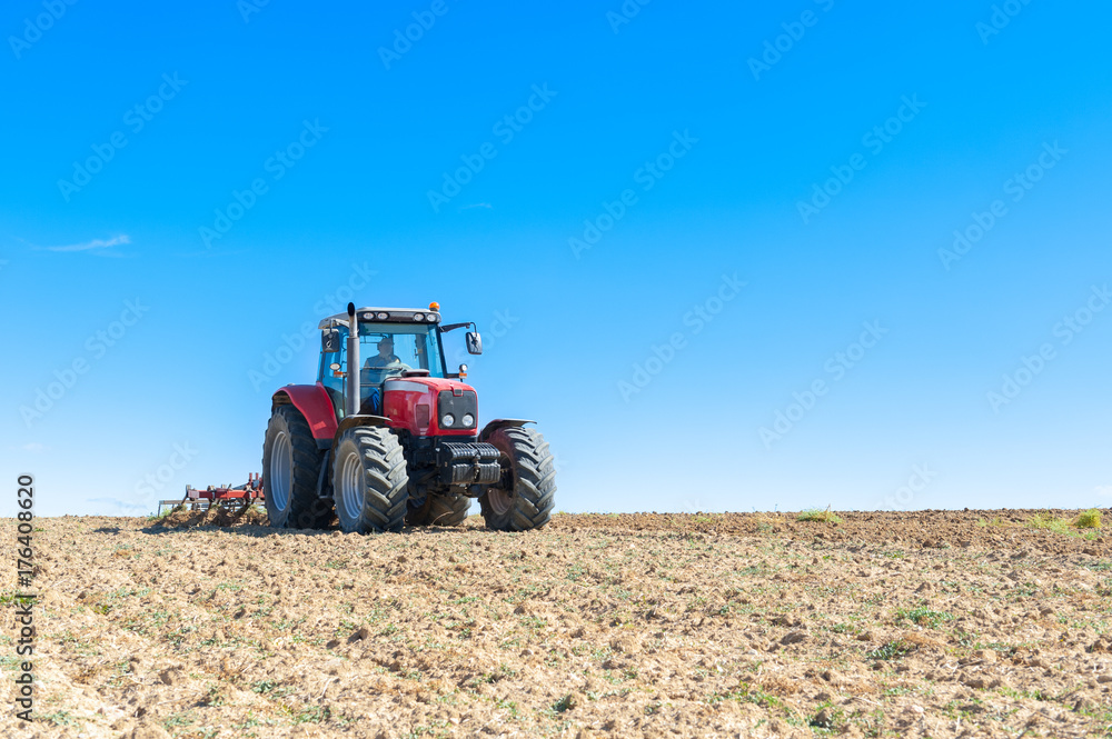 agricultural tractor in the foreground with blue sky background. agricultural tractor in the foreground with blue sky background.