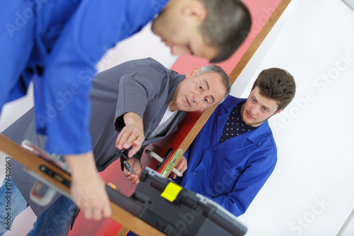 young men learning to fix the door with screwdriver © auremar