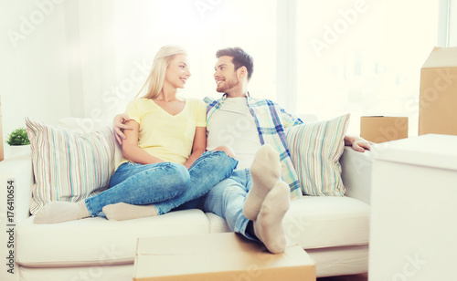 happy couple with big cardboard boxes at new home