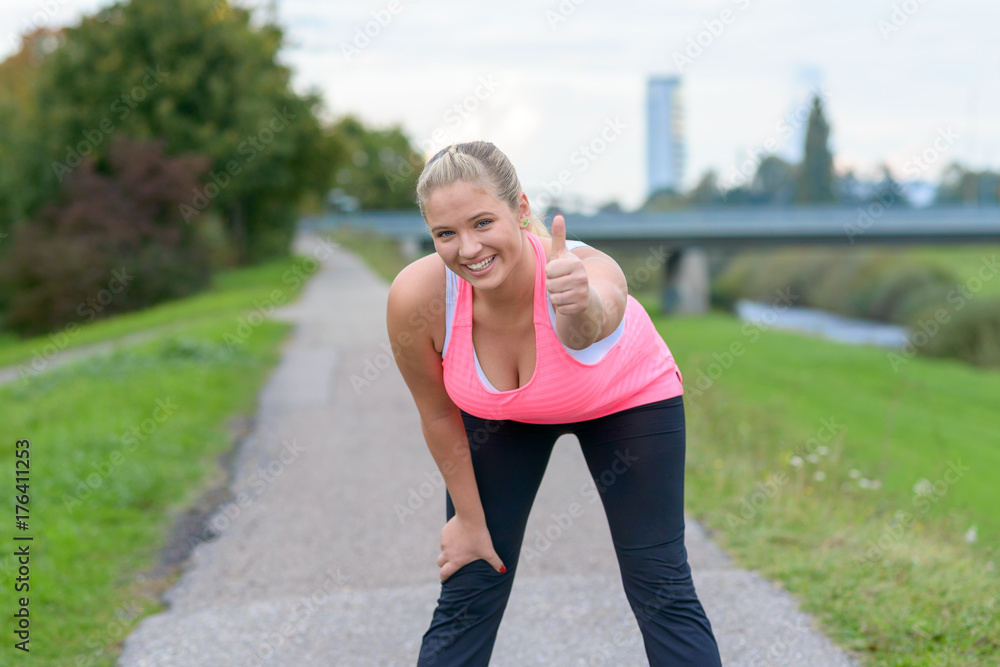 Blonde smiling woman giving thumb up after running