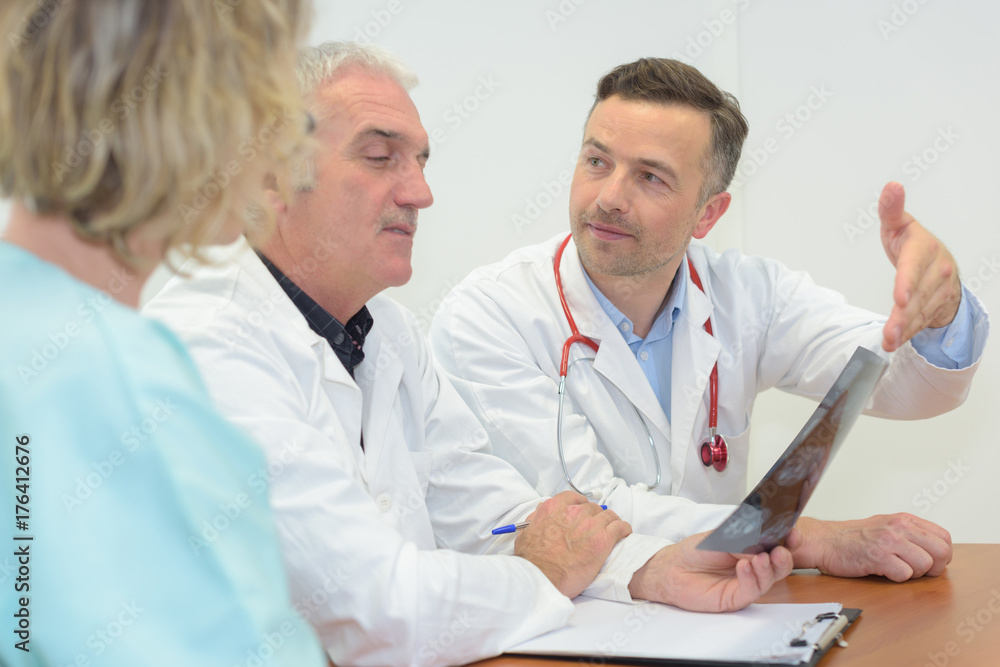 group of doctors meeting and taking notes at medical office group of doctors meeting and taking notes at medical office
