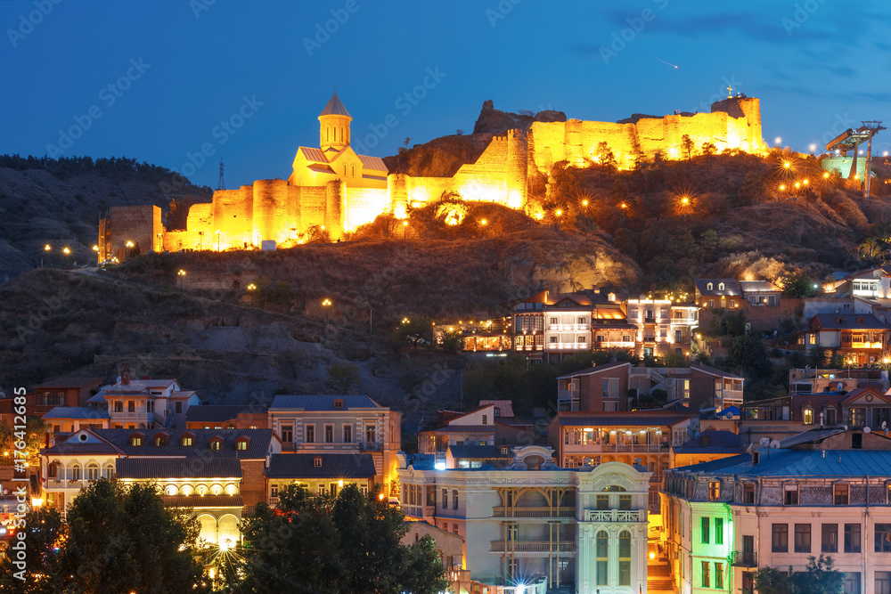 Amazing view of Olt town with Narikala ancient fortress, St Nicholas Church in night Illumination during evening blue hour, Tbilisi, Georgia.