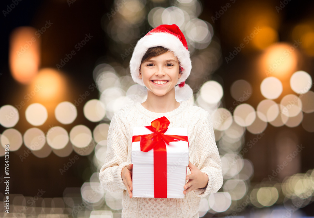 smiling happy boy in santa hat with christmas gift smiling happy boy in santa hat with christmas gift