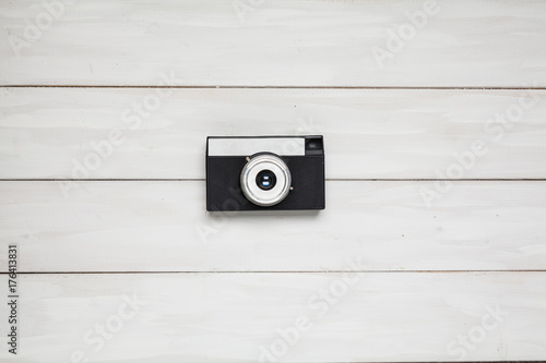 A small black camera on a wooden table. View from above. Outdated. photo