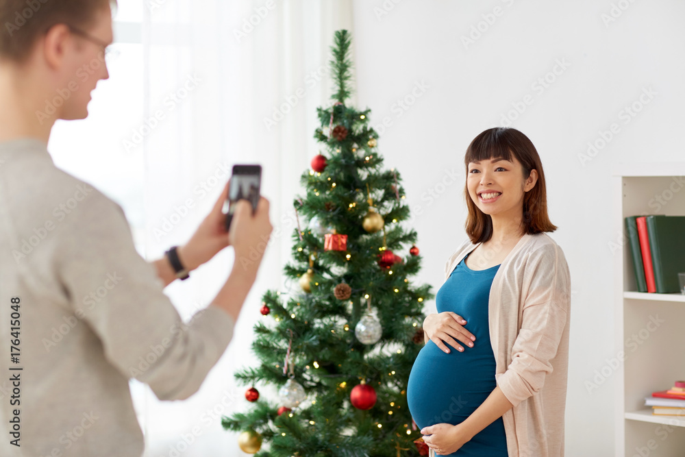 husband photographing pregnant fife at christmas husband photographing pregnant fife at christmas
