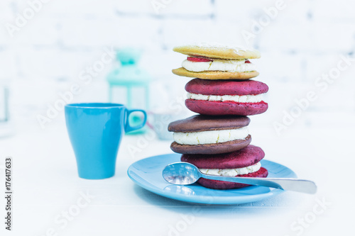 Stack of four whoopie pies or moon pies with cup and spoon. photo