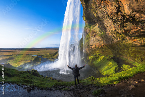 Tourist standing in front of Seljalandsfoss one of the best known waterfalls in southern Iceland  Seljalandsfoss   Iceland