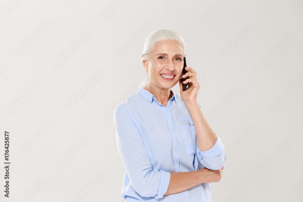 Smiling mature woman talking on smartphone isolated Smiling mature woman talking on smartphone isolated