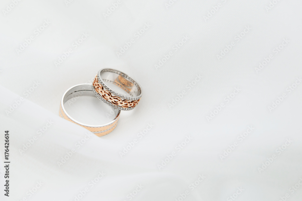 Engagement rings on a soft white background fabric. A wedding ring is a symbol of love and happiness. Engagement rings on a soft white background fabric. A wedding ring is a symbol of love and happiness.