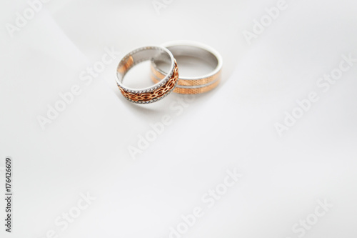 Engagement two rings on a soft white background fabric. A wedding ring is a symbol of love and happiness.