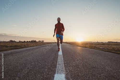 Uomo che corre su strada asfaltata