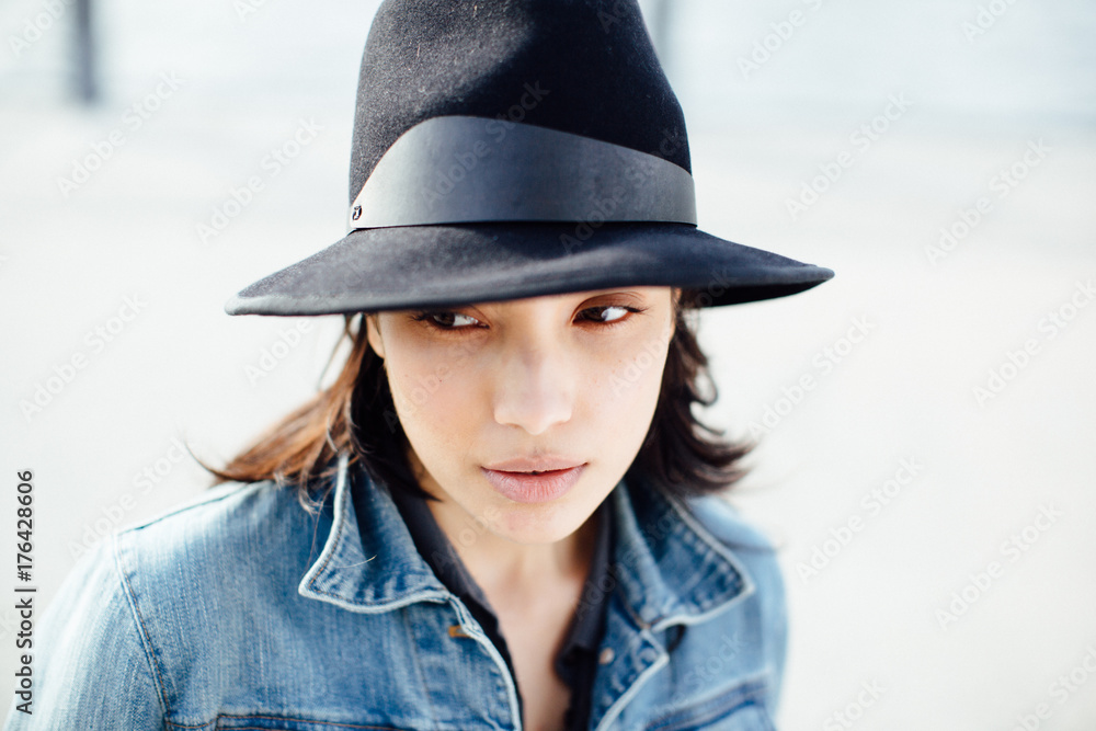Portrait of beautiful young hispanic woman with hat and jeans jacket Portrait of beautiful young hispanic woman with hat and jeans jacket