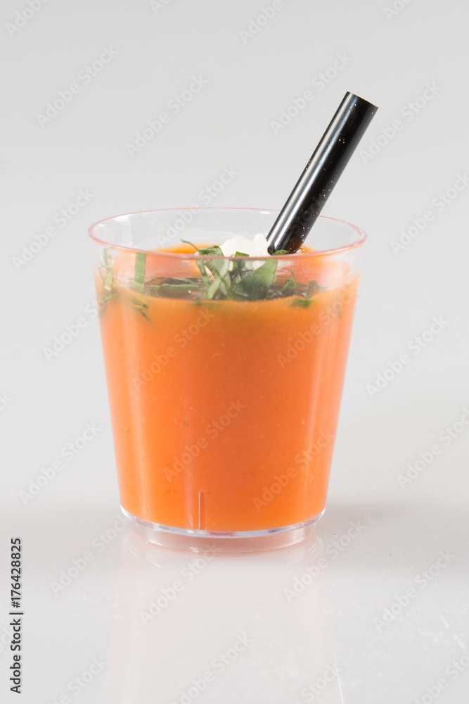 cup of tomato gazpacho soup with green pesto sauce, salt and basil cup of tomato gazpacho soup with green pesto sauce, salt and basil