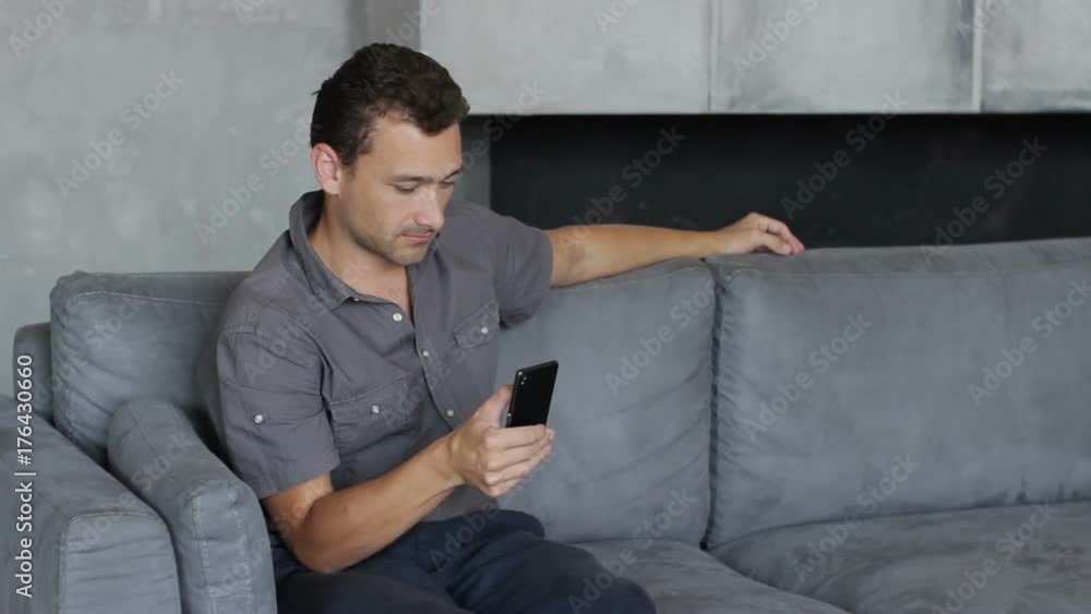 a man plays games on a smartphone. the person spends his leisure online. businessman at home working in the app. work and relax a man plays games on a smartphone. the person spends his leisure online. businessman at home working in the app. work and relax
