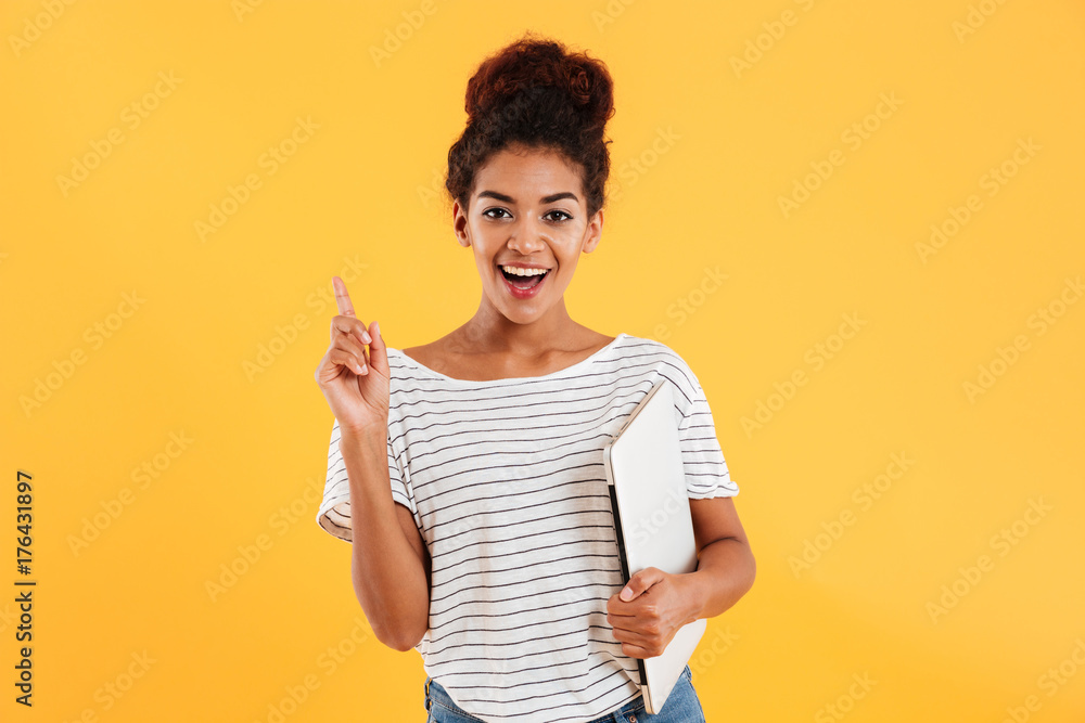 Pretty african lady holding laptop and looking camera Pretty african lady holding laptop and looking camera