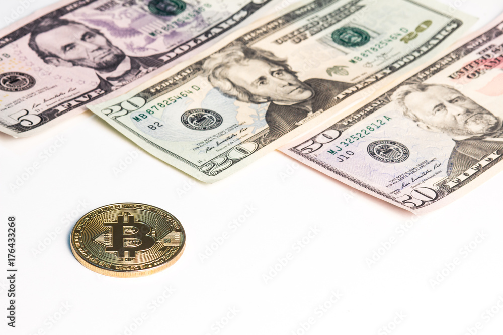 New banknotes of US dollars and a gold coin of crypto currency on a white background. New banknotes of US dollars and a gold coin of crypto currency on a white background.