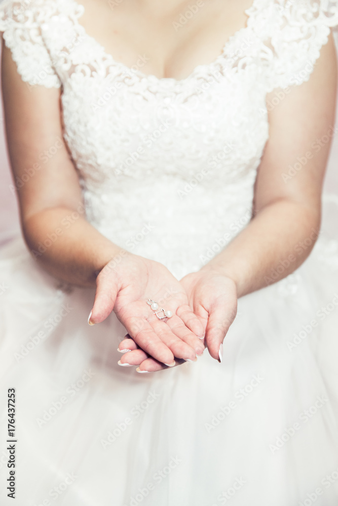 Bride hands holding earrings Bride hands holding earrings