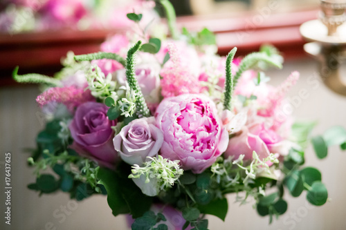 Rustic wedding bouquet with white roses  crimson peonies  and greens on a wooden floor. Indoors.