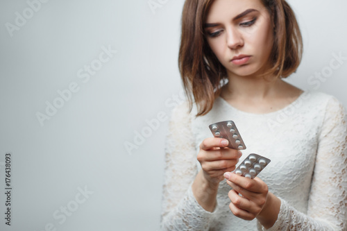 Young girl in jeans with pills in hands