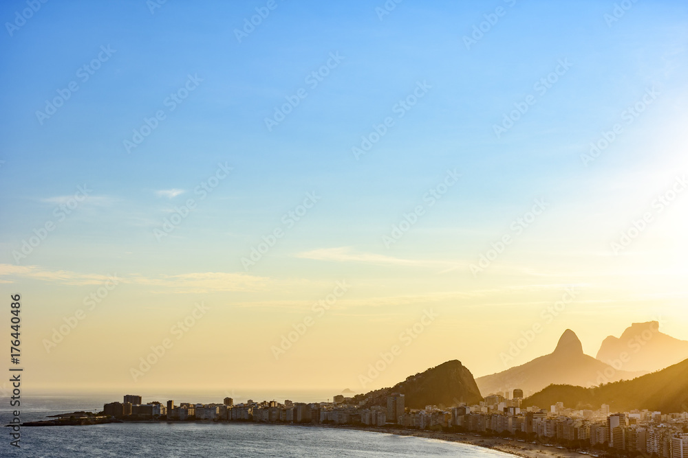 Copacabana beach in Rio de Janeiro during sunset with its buildings and the mountains in the background