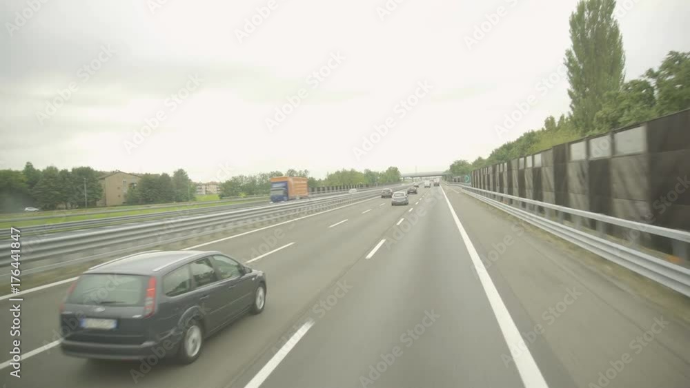 View to the European modern highway from riding car. Cloudy weather, green landscape, moving cars. View to the European modern highway from riding car. Cloudy weather, green landscape, moving cars.
