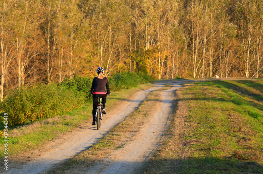 Cycling, mountain bikeing woman on cycle trail in autumn forest.