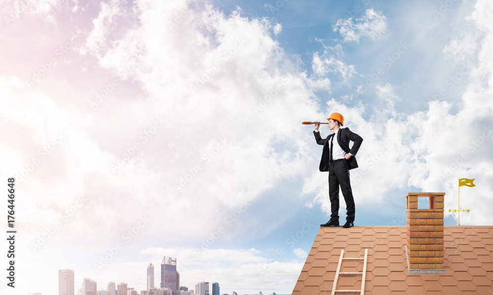 Engineer man standing on roof and looking in spyglass. Mixed media Engineer man standing on roof and looking in spyglass. Mixed media