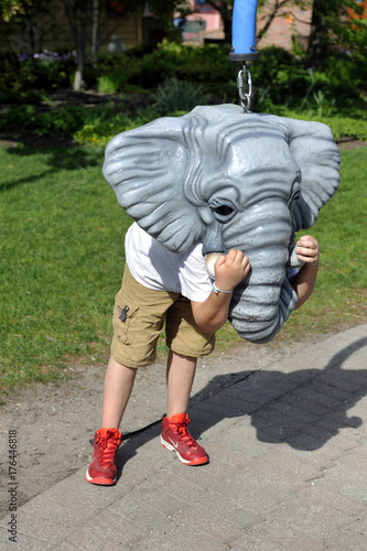 boy with toy elephant head and red shoes