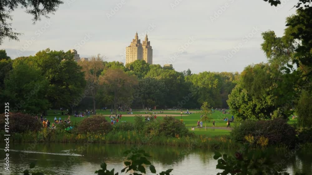 People enjoy Central Park on an early Autumn evening with the iconic New York City skyline in the distance. People enjoy Central Park on an early Autumn evening with the iconic New York City skyline in the distance.