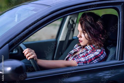 Side portrait of young woman driving a car on high speed