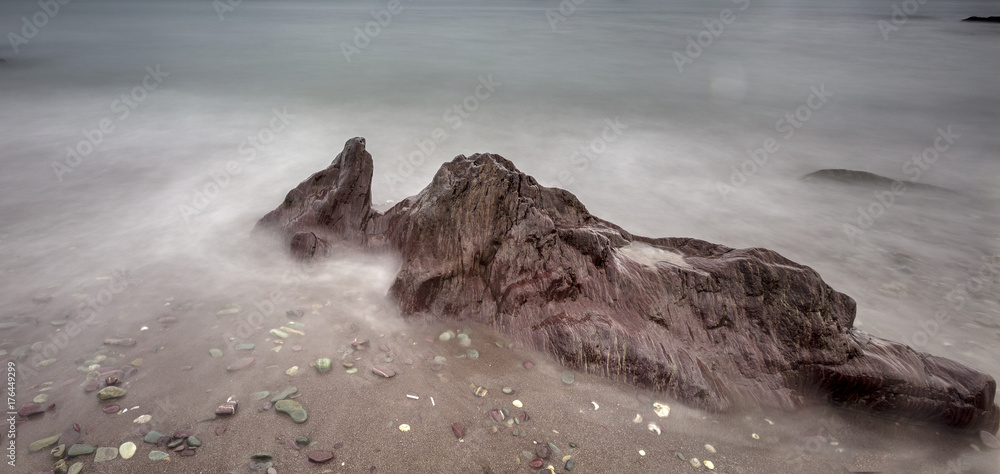 Obraz premium Rocks on seashore - long exposure, sea movement