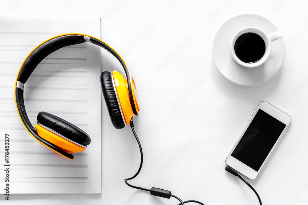 Worktable of composer today. Headphones, phone, music notes on white background top view - obrazy, fototapety, plakaty 