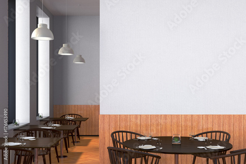 Modern restaurant interior with served tables and blank poster