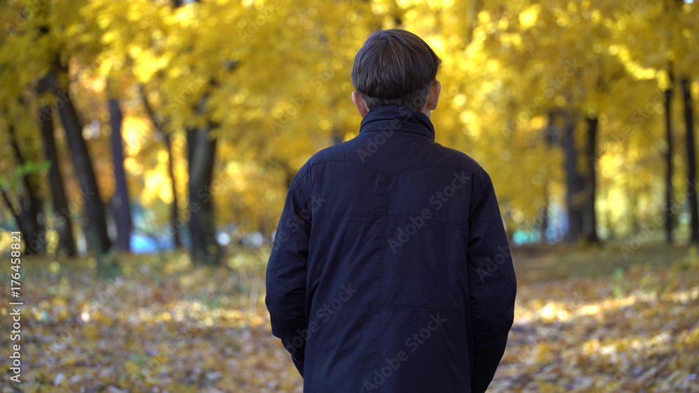 young guy in a black coat in the autumn park. young guy in a black coat in the autumn park.