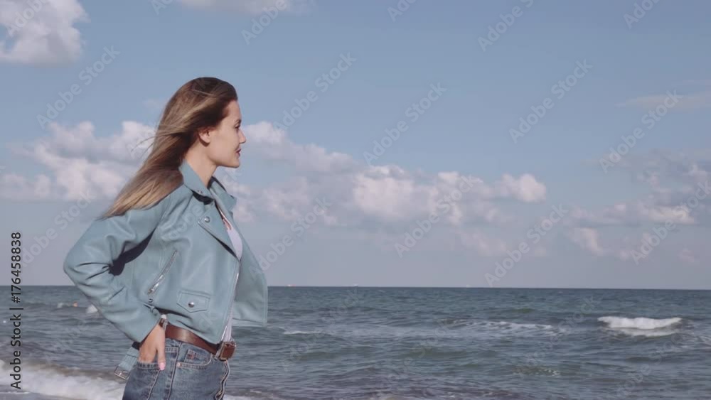 Young beautiful happy woman admiring the sea in the rays of a bright sun Young beautiful happy woman admiring the sea in the rays of a bright sun