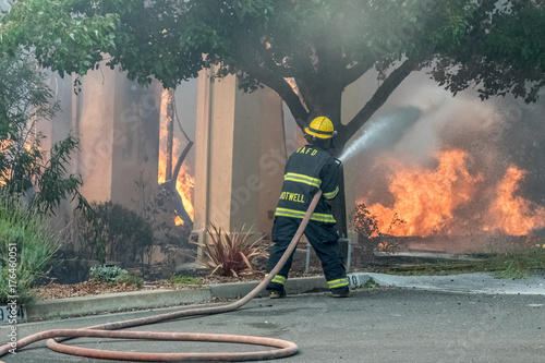 Firefighter defending house on fire. Sonoma County, California, United States, Monday, 9th October, 2017. Devistation throughout county. photo