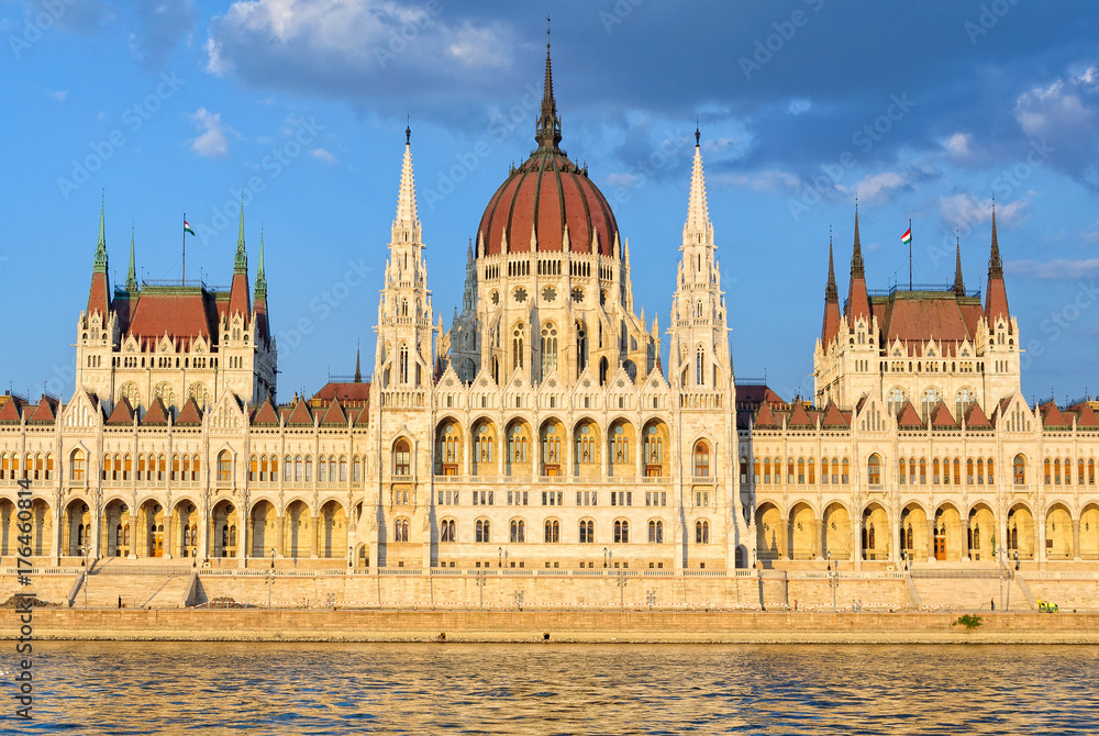 The symmetrical main facade and the central dome of the Hungarian Parliament Building overlook the River Danube - Budapest, Hungary