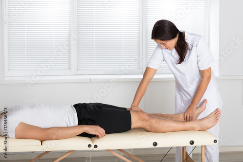 Physiotherapist Massaging Man's Leg