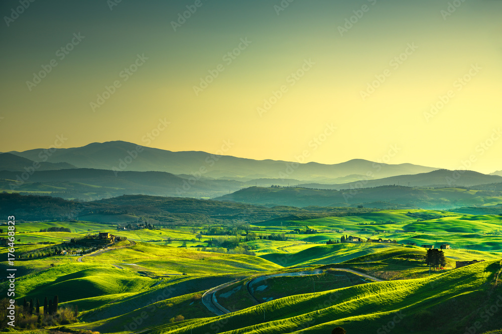 Volterra panorama, rolling hills, trees and green fields at sunset. Tuscany, Italy