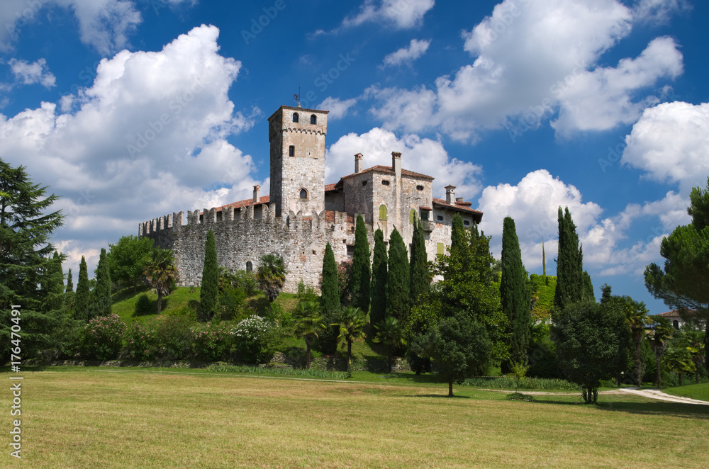 Cloudy sky in a sunny day over the medieval Villalta castle, Fagagna, Friuli, Italy

