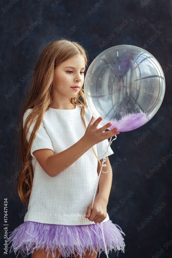Beautiful little girl with wavy hair posing in a dress Beautiful little girl with wavy hair posing in a dress