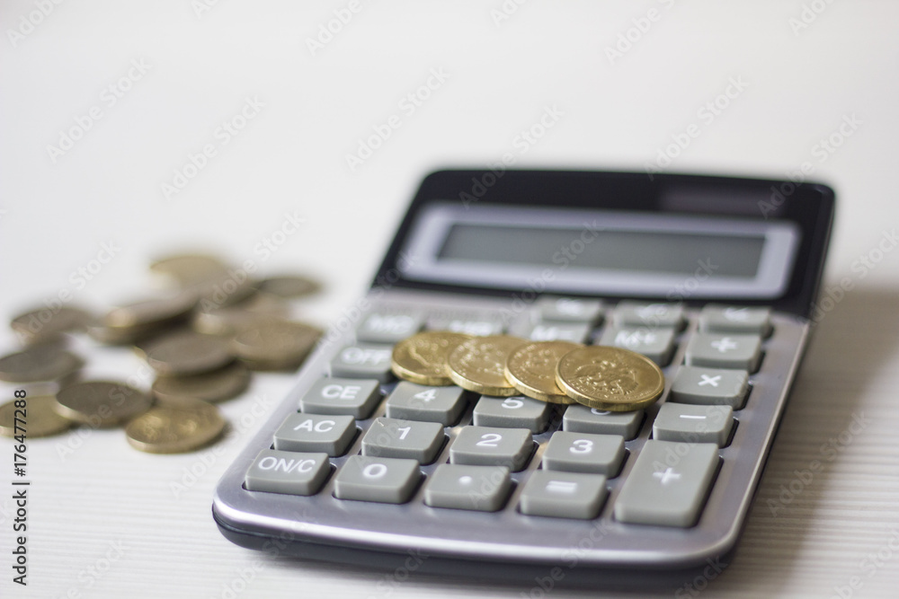 Money concept. Calculator with coins on wooden table Money concept. Calculator with coins on wooden table