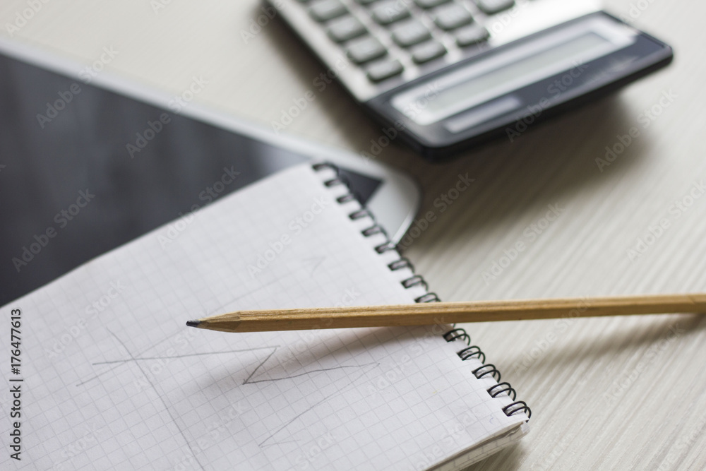 Notepad, calculator and a pencil are on the table Notepad, calculator and a pencil are on the table
