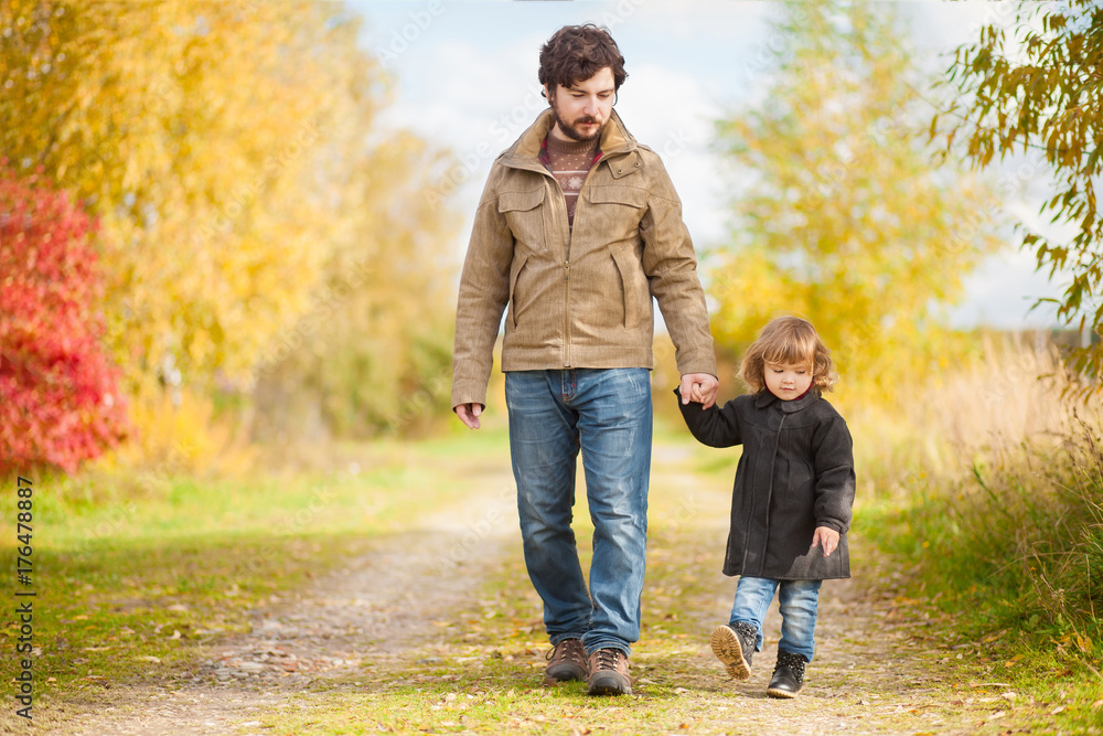 Fototapeta premium Father and daughter walking together, autumn day.