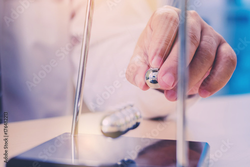 Close-up of businessman hand's release the Newton's cradle ball. business effect concept