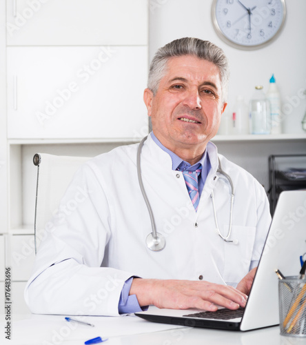 Mature doctor in his office